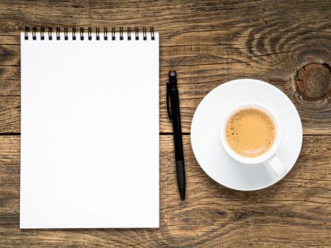 open-notepad-with-spiral-pen-and-coffee-cup-AED9JJJ