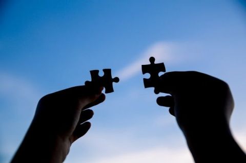 two-hands-trying-connect-couple-puzzle-piece-with-sunset-background_1150-17513